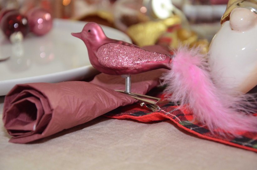 Weihnachtsbaumschmuck ein Marsala farbender Vogel mit Federn der als Serviettenhalter dient.